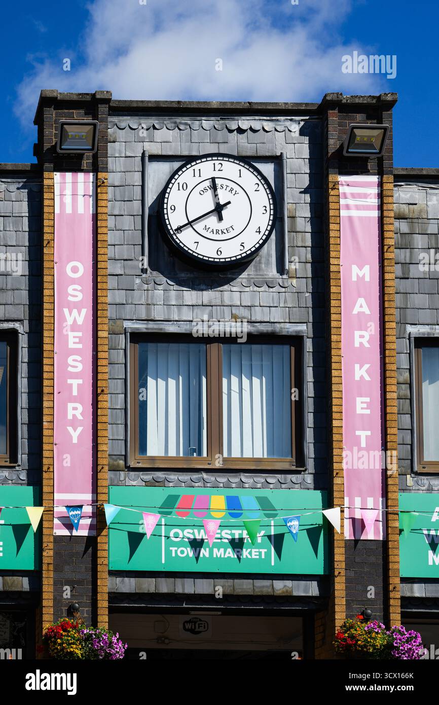 Oswestry, England, Großbritannien - 29. August 2025; Schilder und Uhr auf dem Powis Hall Indoor Market außen Stockfoto