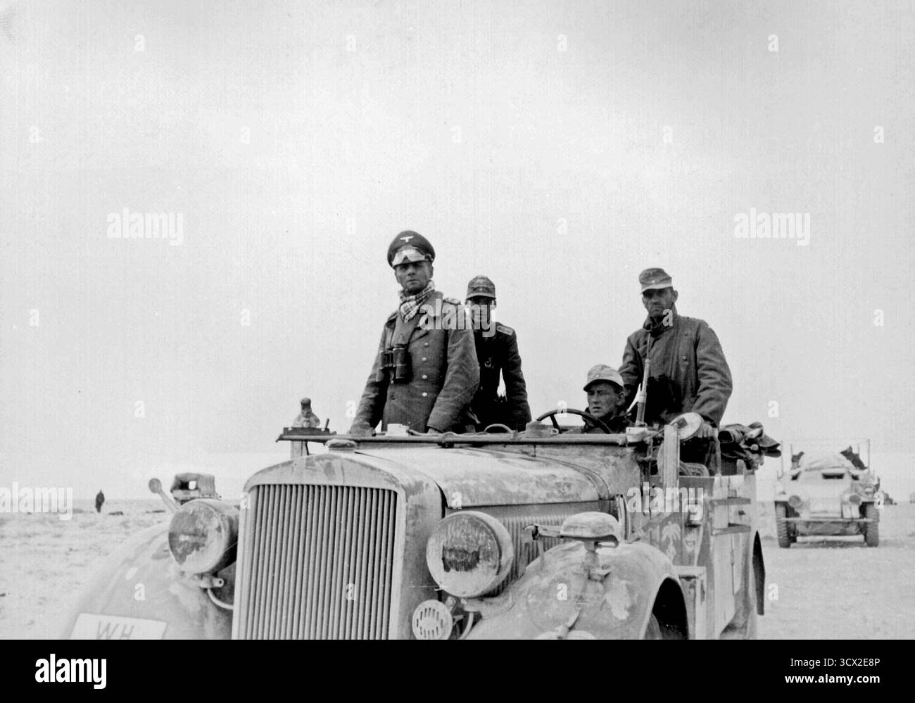 TOBRUK, LIBYEN – um den 20. November 1941 – der Afrikakorps General Erwin Rommel, genannt Wüstenfuchs, in seinem Skoda Supreme Kfz-Stabwagen mit der 15. Panzerdivision zwischen Tobruk und Sidi Omar, Libyen. Trotz des selbstbewussten Aussehens in diesem Bild hätte General Rommel sich zurückgezogen, als dieses Foto aufgenommen wurde - wahrscheinlich um den 20. November 1941 - und Tage bevor die Eroberung Tobruks durch die Operation Crusader aufgehoben wurde, ein massiver Angriff der alliierten Achten Armee, der in vielerlei Hinsicht die Niederlage des Afrika-Korps in Nordafrika markierte - Foto: Geopix/Zwilling Stockfoto