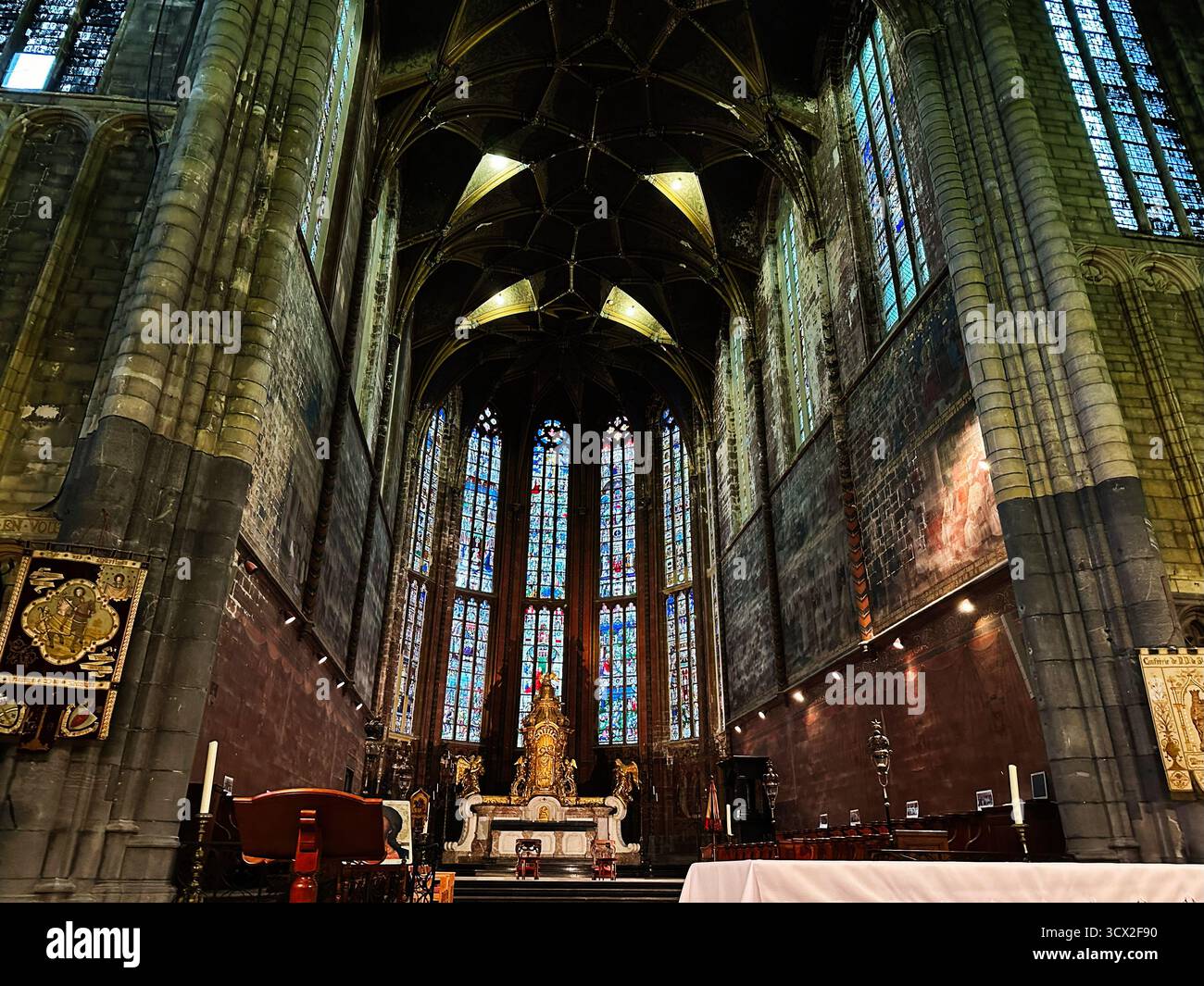 Lüttich, Belgien - 20. Oktober 2023: Eine große gotische Kirche St. Martin in Belgien mit hohen Bögen, bunten Buntglasmalereien und heiligem Altar Stockfoto