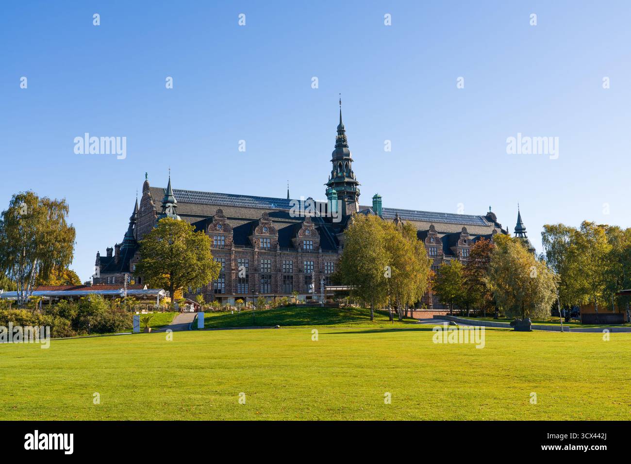 Das Nordische Museum auf Djurgården, Stockholm, Schweden, mit tiefblauem Himmel und wunderschönen Herbstfarben auf den Blättern der Bäume Stockfoto