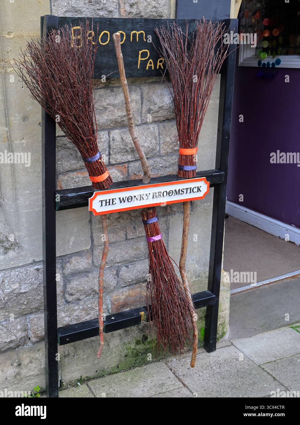 Halloween-Besen parken vor einem Geschäft, Glastonbury, Somerset, Südwestengland, Großbritannien. Vom Oktober 2025 im Herbst Stockfoto