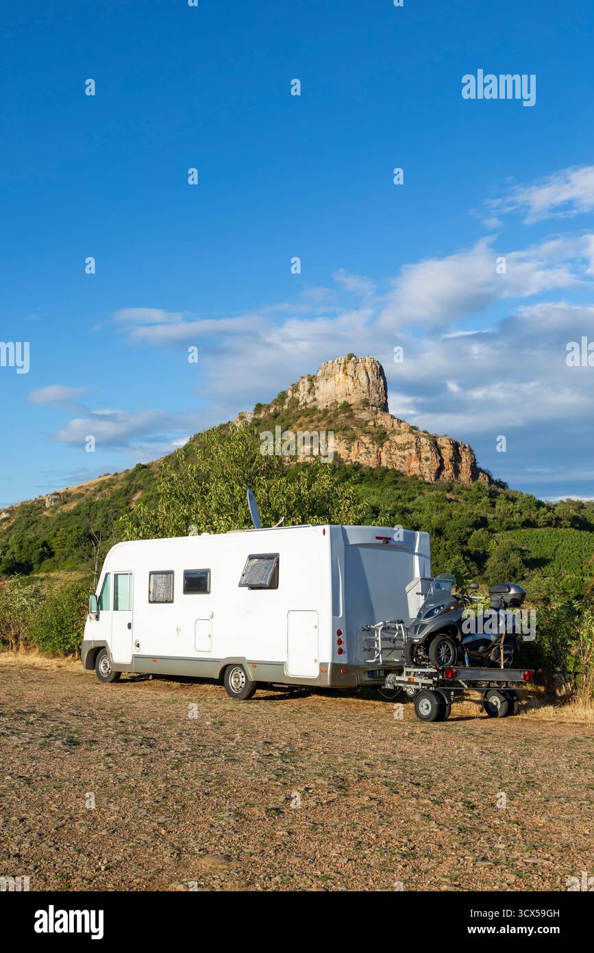 Wohnmobil mit Rolleranhänger, geparkt gegen die berühmte Roche de Solutre in Frankreich Stockfoto