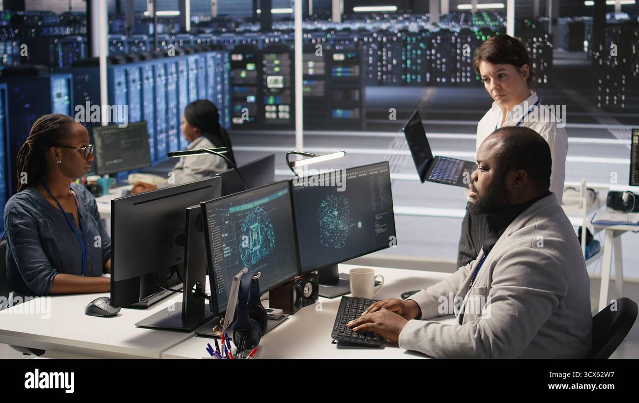 Zufriedener Rechenzentrumsmanager gibt dem Entwickler von Software für neuronale Netzwerke auf dem Computer positives Feedback. Fröhlicher Vorgesetzter zufrieden mit der Arbeit der Mitarbeiter bei der Implementierung von KI im Serverraum, Kamera A Stockfoto