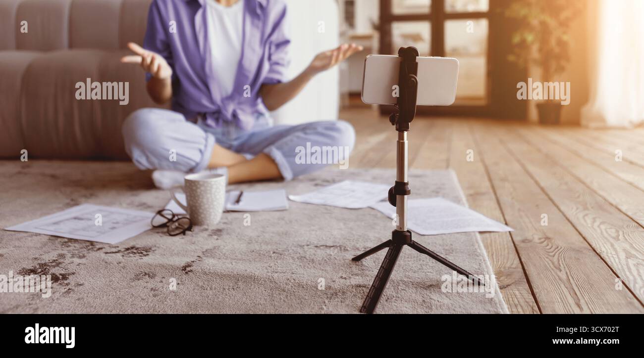 Einrichtung der Arbeit per Fernzugriff mit Videoanruf auf dem Smartphone im gemütlichen Wohnzimmer am Nachmittag Stockfoto