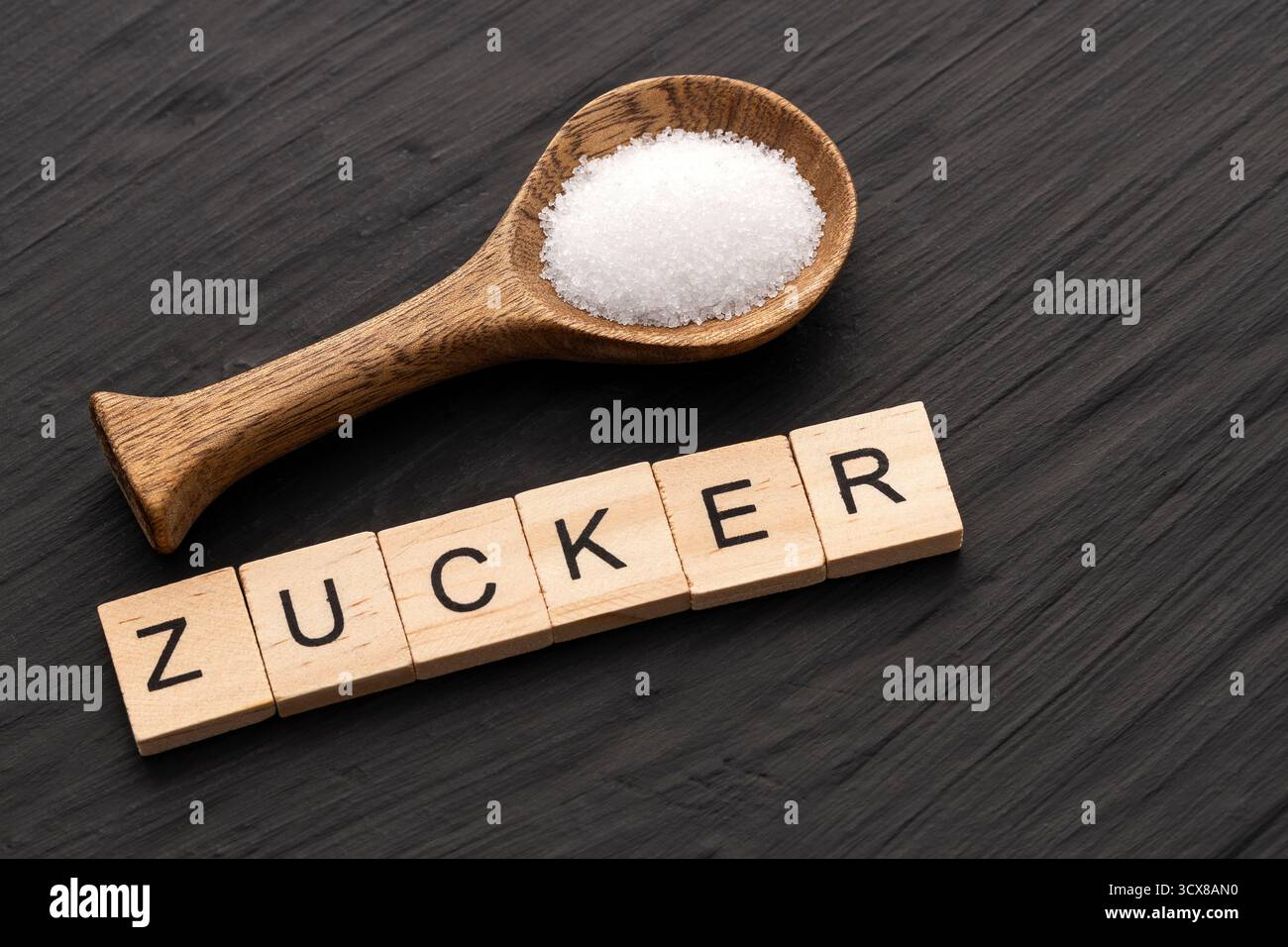 Feine Kristalle von raffiniertem Weißzucker - das Wort "Zucker" übersetzt ins Deutsche Stockfoto