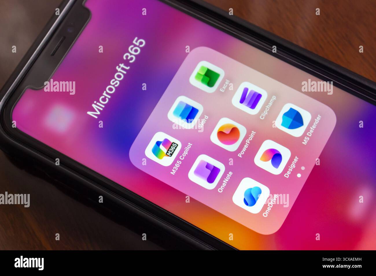Nahaufnahme einer Microsoft 365-App (M365 Copilot, Word, Excel, OneNote, PowerPoint, Clipchamp, OneDrive Microsoft Designer, MS Defender) auf einem iPhone. Stockfoto