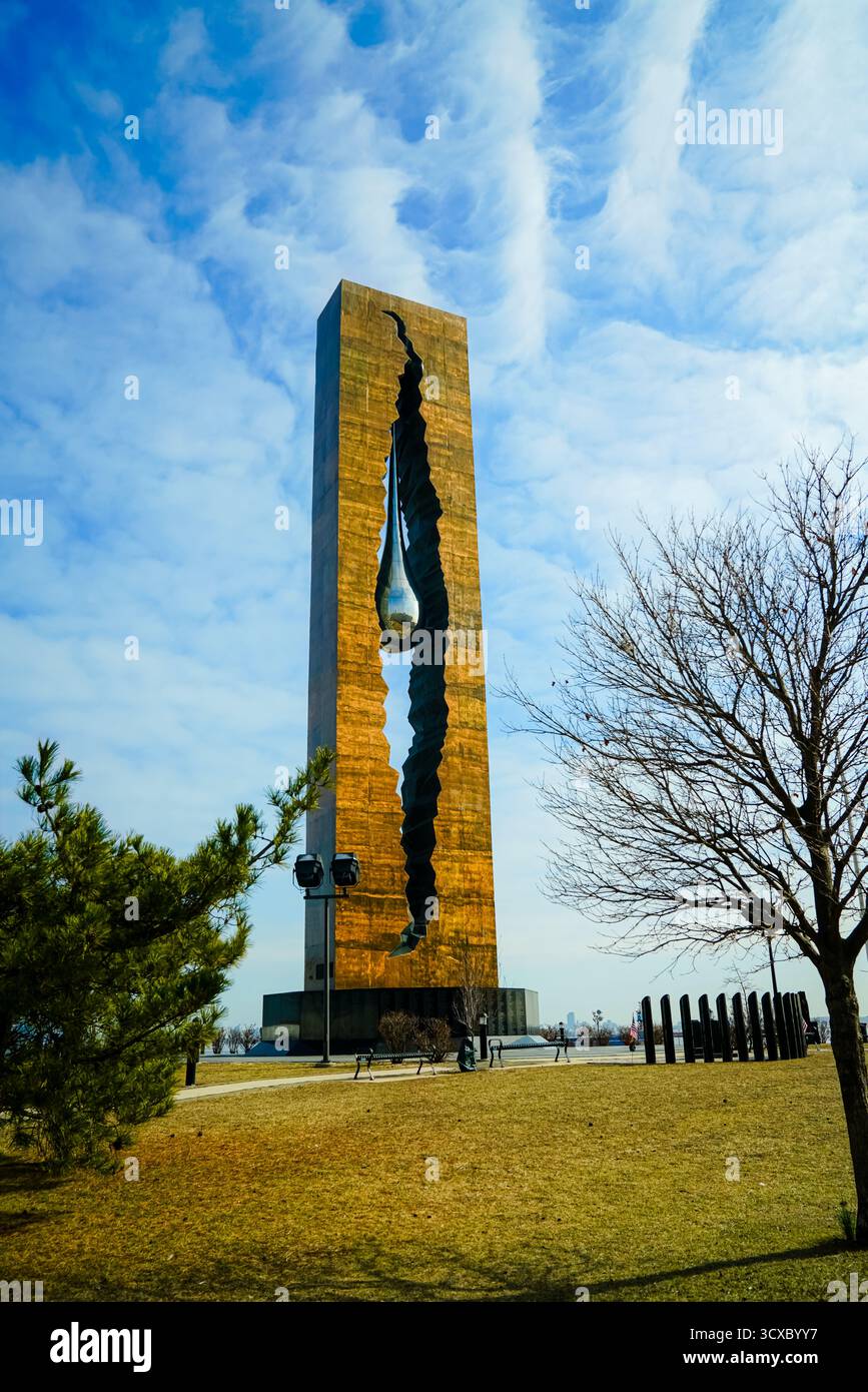 Das Tears Drop Memorial in Bayonne, New Jersey, steht hoch unter einem leuchtend blauen Himmel, dessen reflektierende Skulptur Frieden, Erinnerung und Einheit symbolisiert Stockfoto