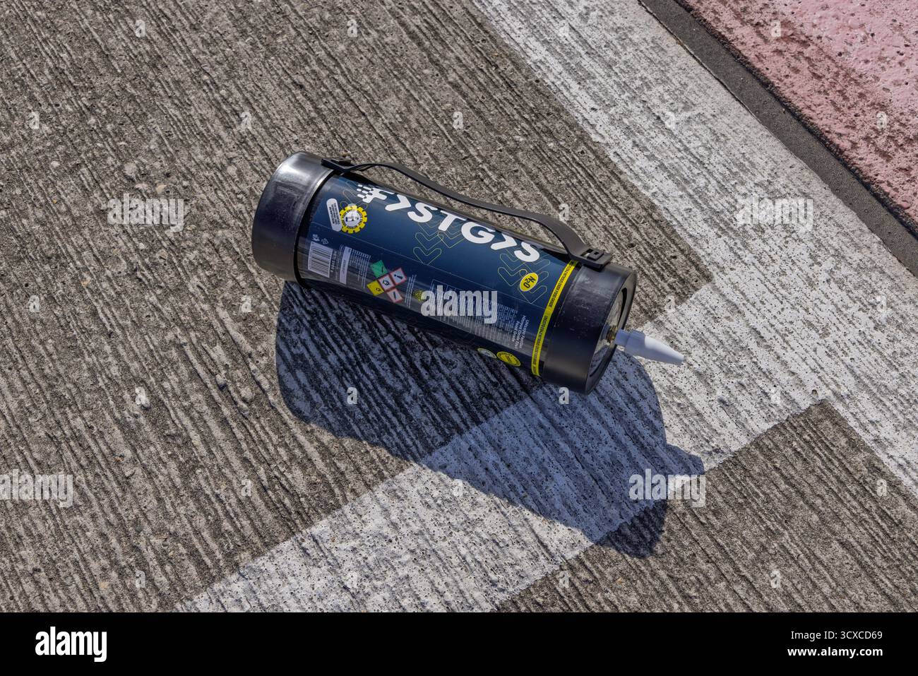 Nahaufnahme einer Lachgas-Gasflasche auf Straßenmarkierung, Gefahrgut mit klarem Etikett und hellem Sonnenlicht. Utrecht, Netherla Stockfoto