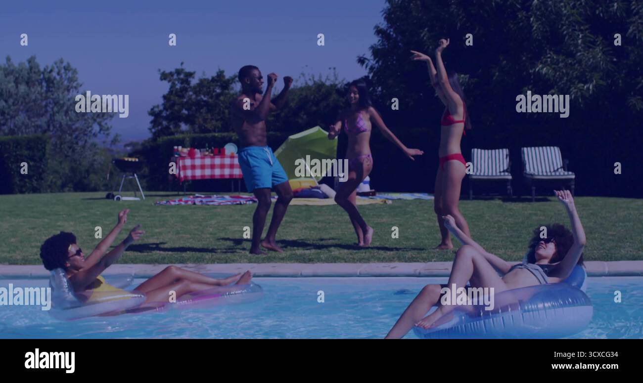 Schwimmende Freunde in Badeanzügen auf Schwimmschläuchen und tanzen im Hinterhofpool mit Picknicktisch Stockfoto