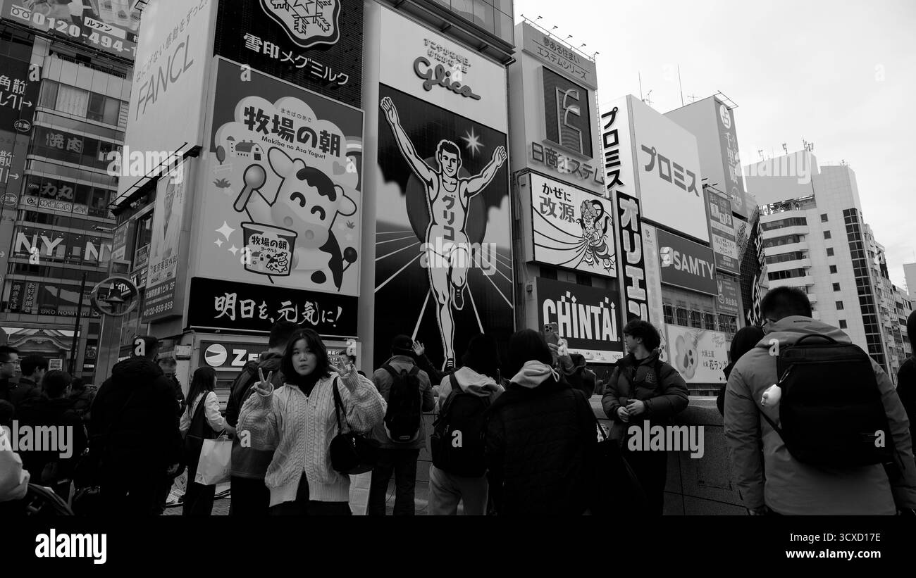 Besucher treffen sich unter dem berühmten Glico Running man-Schild im Dotonbori-Viertel von Osaka Stockfoto