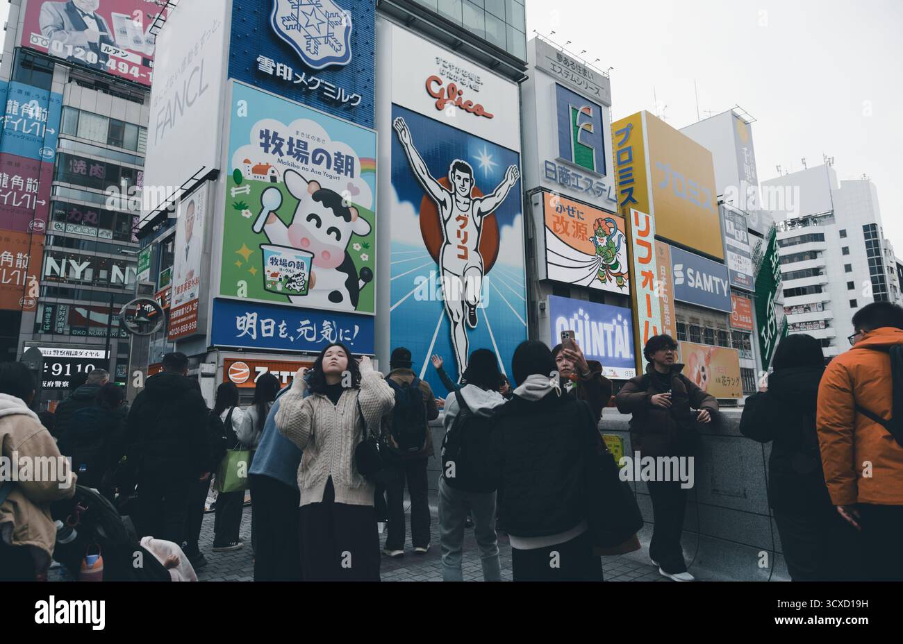 Touristen treffen sich vor Osakas berühmtem Glico Running man Schild in Dotonbori Stockfoto