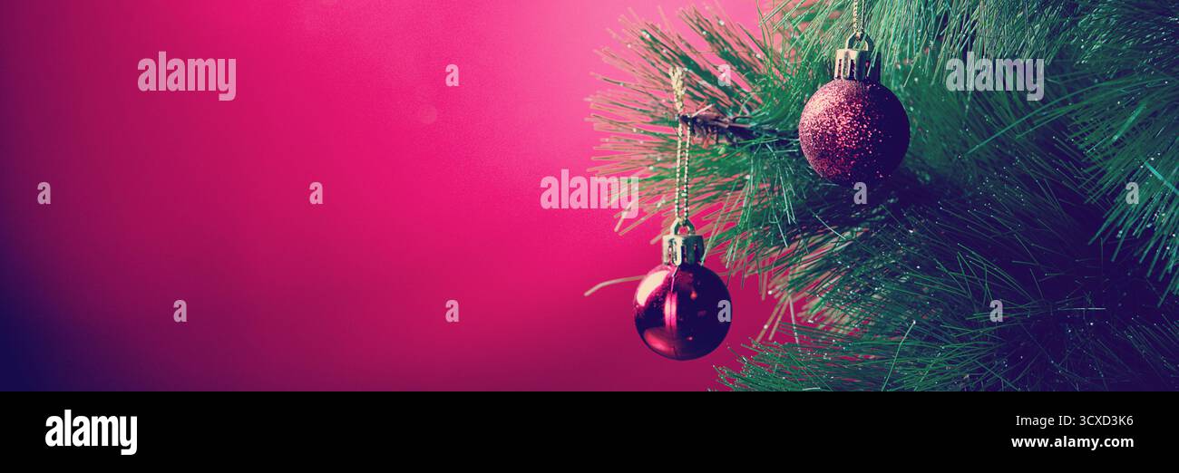 Rote Weihnachtskugeln auf Weihnachtsbaum auf rotem Hintergrund Stockfoto