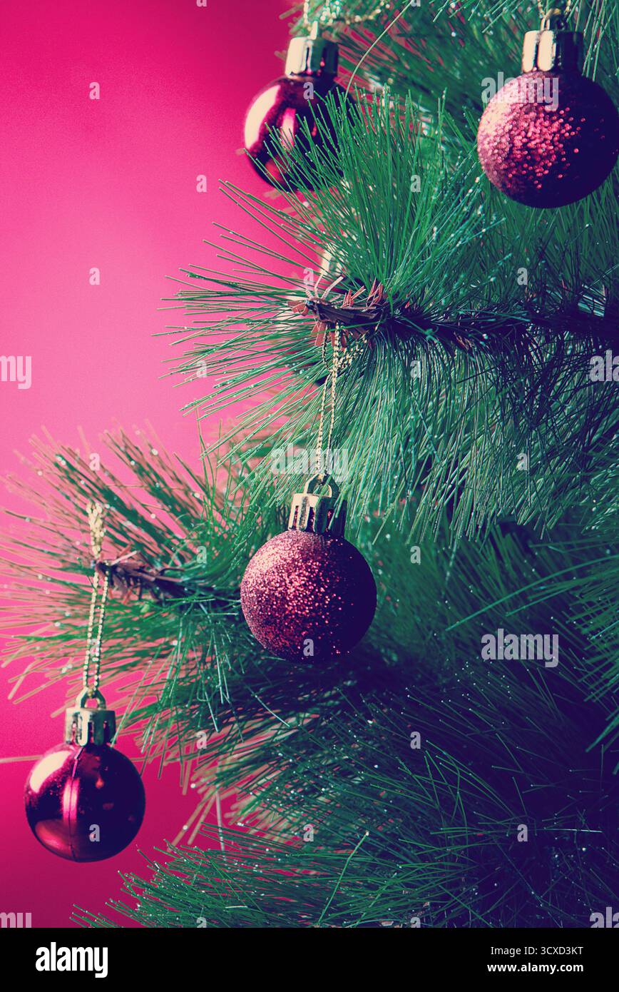 Rote Weihnachtskugeln auf Weihnachtsbaum auf rotem Hintergrund Stockfoto