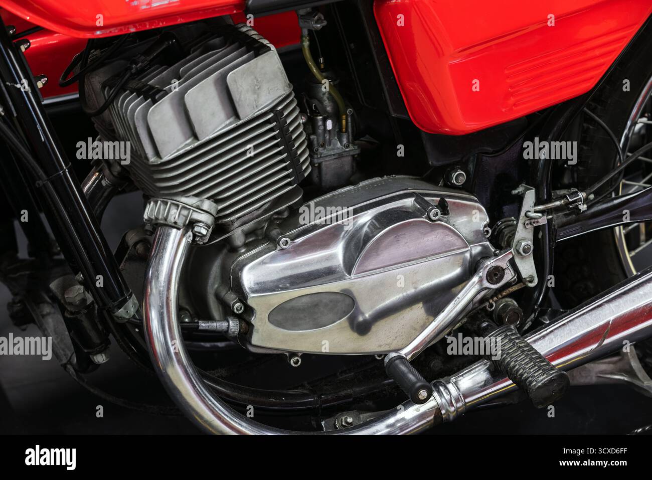 Eine detaillierte Nahaufnahme eines roten Motorradmotors mit Kühlrippen, Chromgehäuse und dem umliegenden Rahmen. Perfekt für Automobile und Oldtimer Stockfoto
