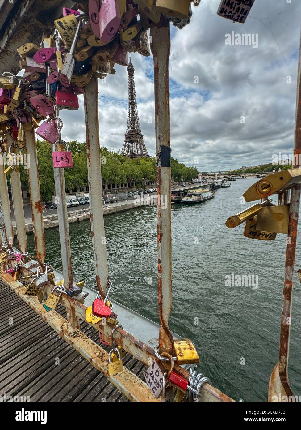 Rostiges Brückengeländer mit Liebesschlössern mit Blick auf den Eiffelturm und die seine in Paris, Frankreich. Symbol für Liebe und Romantik Stockfoto