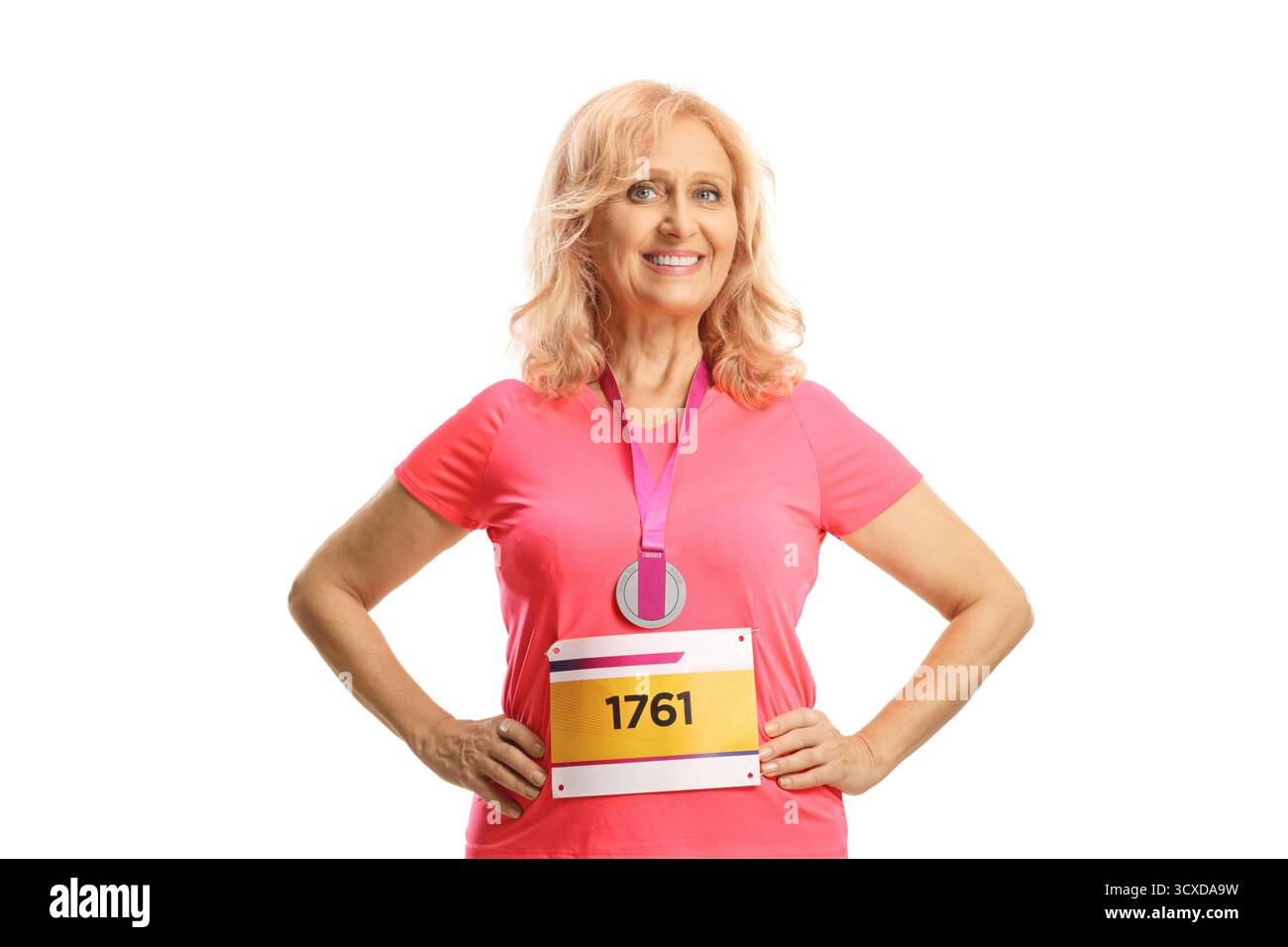 Marathonläuferin mit einem Lätzchen und einer Medaille, die in die Kamera lächelt, isoliert auf weißem Hintergrund Stockfoto