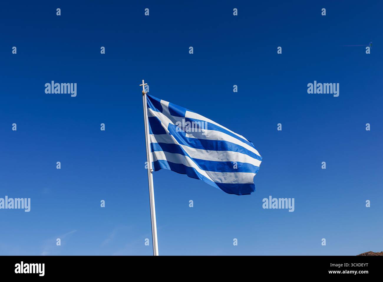 Griechische Flagge winkt gegen einen klaren blauen Himmel. Stockfoto