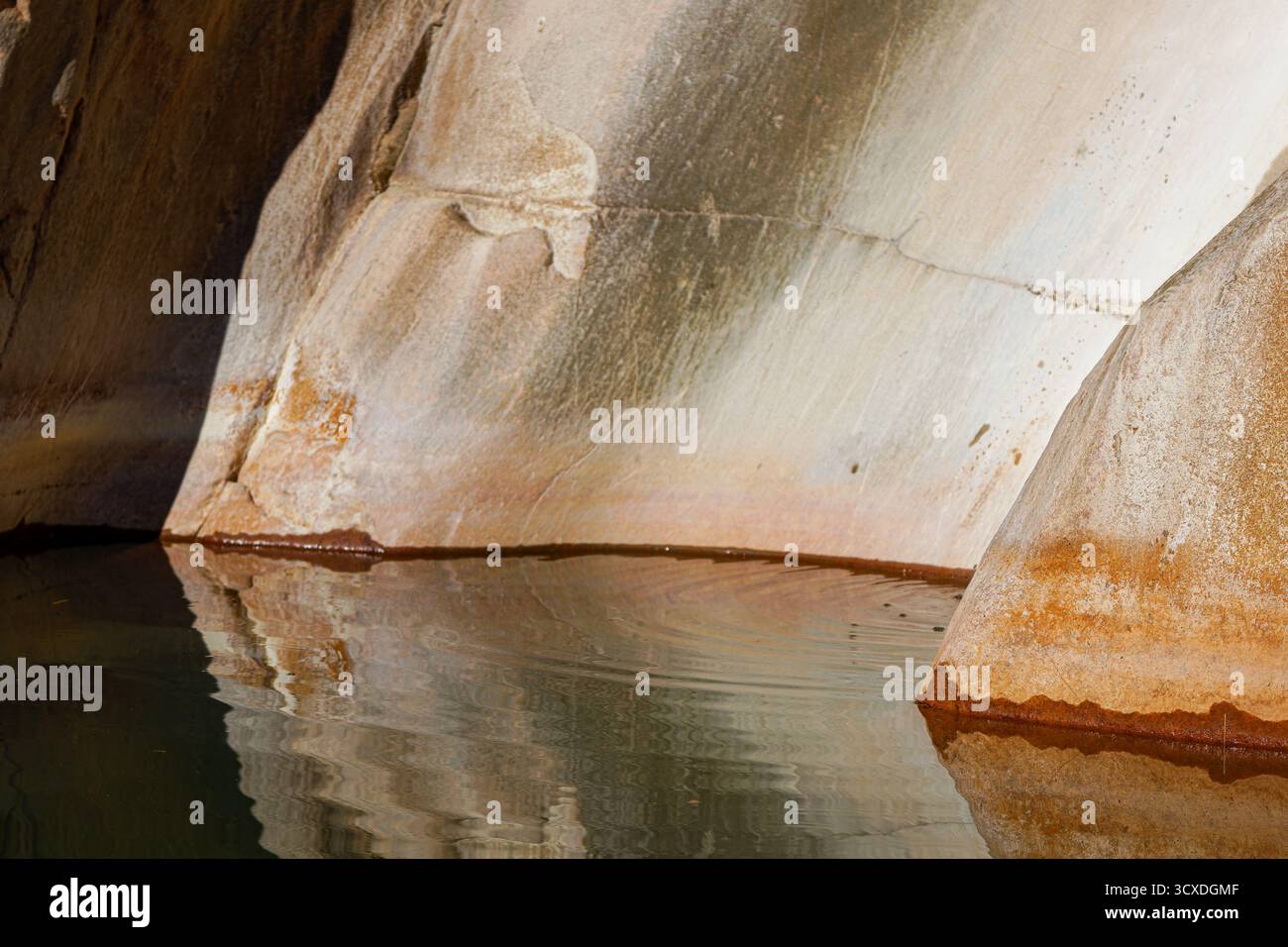 Nahaufnahme von Felsformationen, die sich in ruhigem Wasser spiegeln und natürliche Strukturen und Farben zeigen. Stockfoto