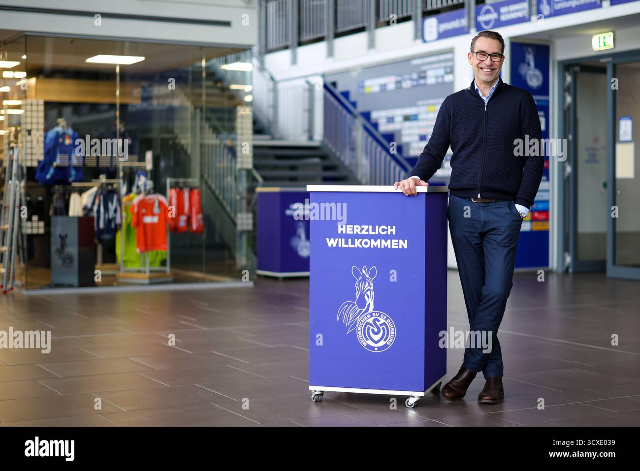 Duisburg, Deutschland. Oktober 2025. Michael Preetz, Geschäftsführer des MSV Duisburg, steht bei einer Fotosession im Stadion des Vereins mit der Aufschrift „Willkommen“ und dem MSV Duisburg-Logo an einem Theken. Quelle: Christoph Reichwein/dpa/Alamy Live News Stockfoto
