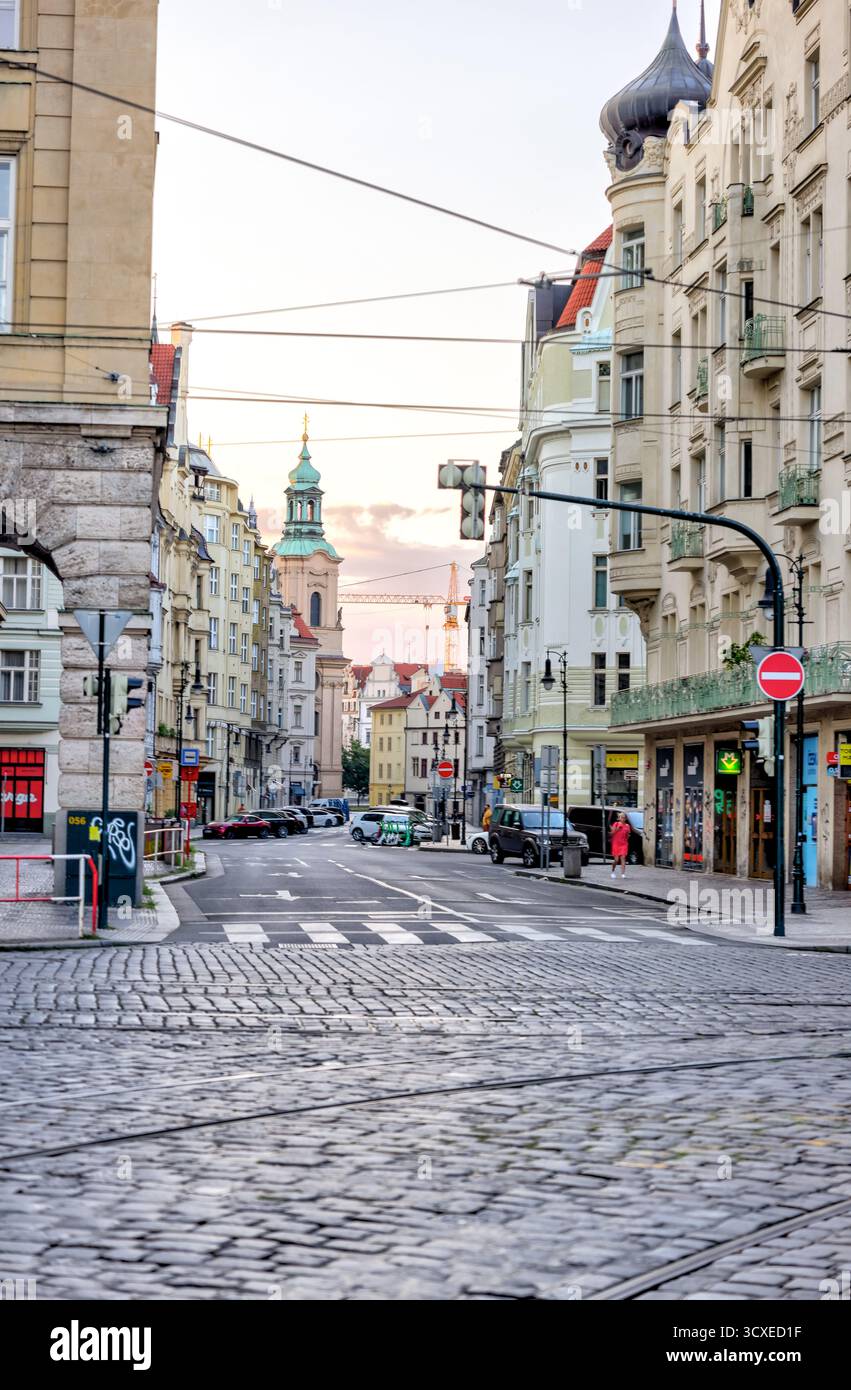 Straßenbahnen und Fußgänger am Jungmannovo-Platz im Zentrum von Prag, mit farbenfrohen historischen Gebäuden und Straßenbahnleitungen an einem bewölkten Tag. Stockfoto