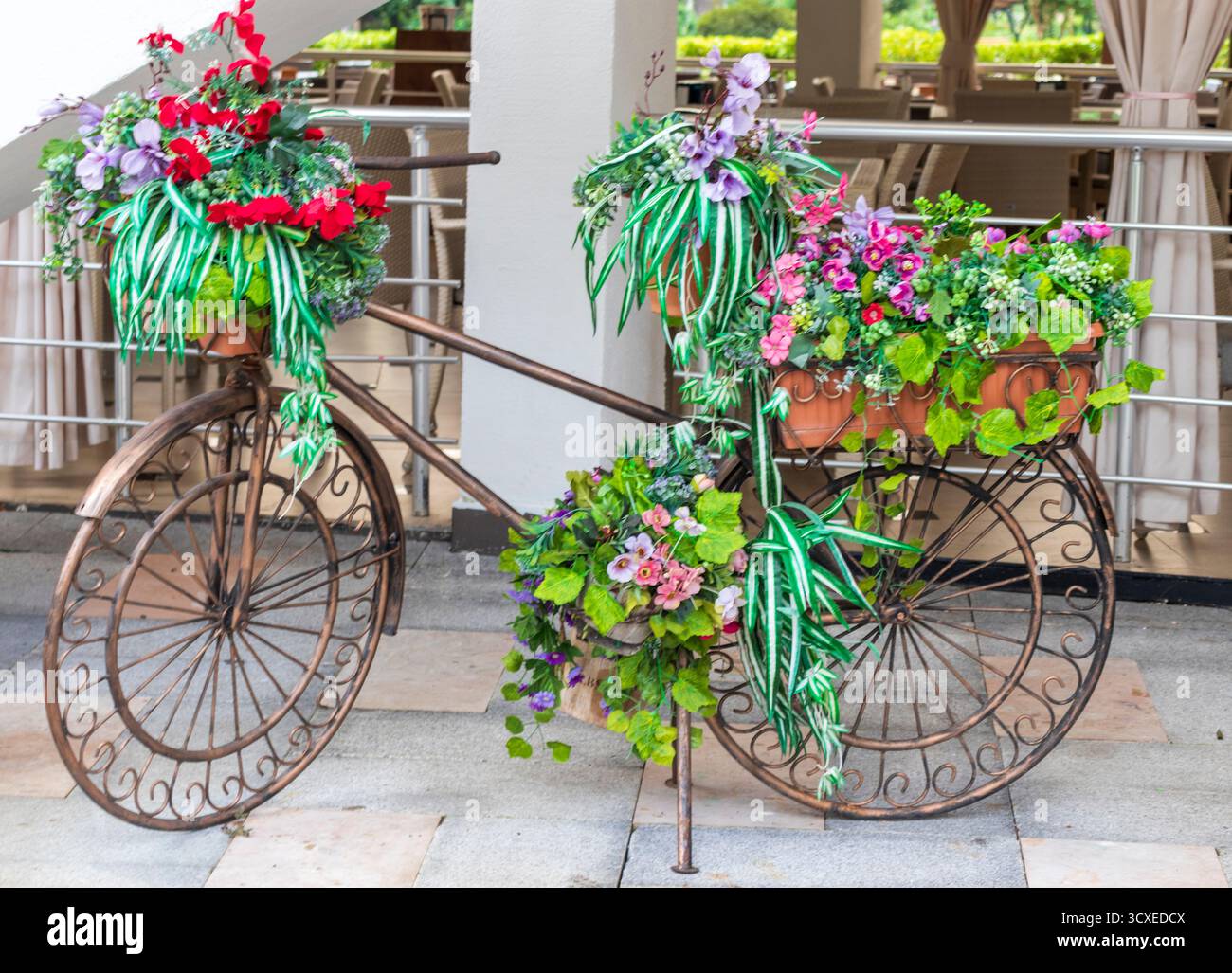 Metalldekoration vor dem Sommercafé, in Form eines Fahrrads und mit Blumen dekoriert Stockfoto