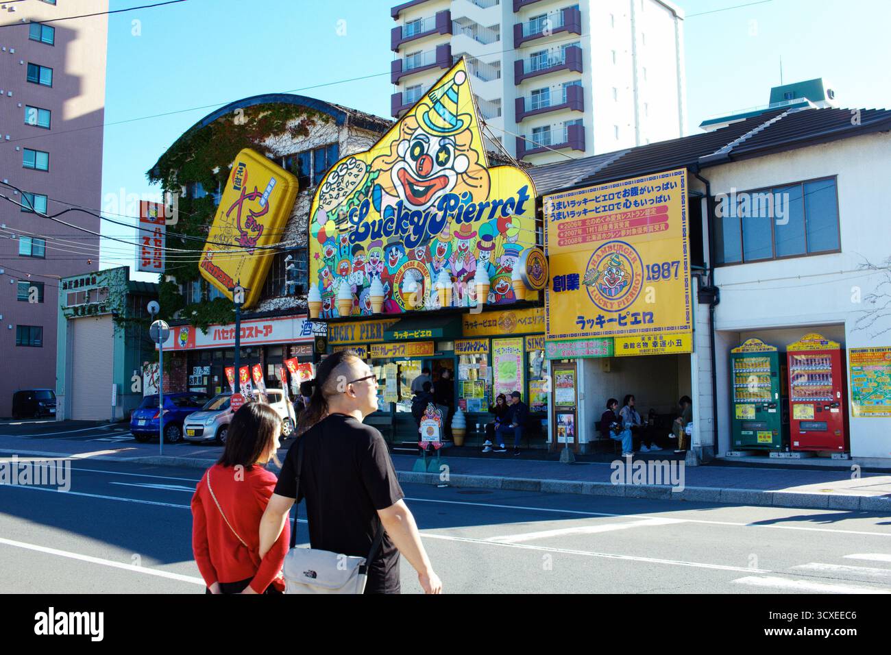 HAKODATE, JAPAN - 27. September 2025: Ein paar Spaziergänge am berühmten Lucky Pierrot Burger Restaurant vorbei, einer berühmten lokalen Kette, die für ihr skurriles Maskottchen bekannt ist. Stockfoto
