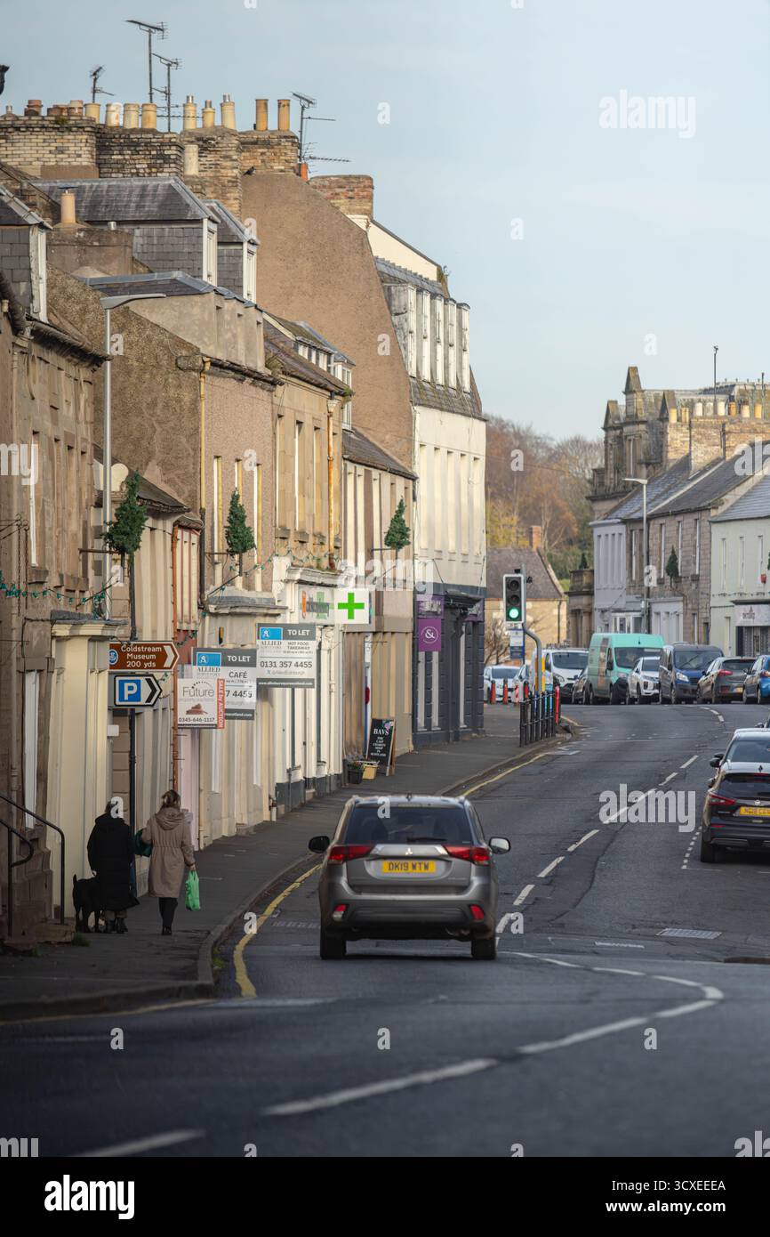 Blick auf die Straße entlang der High Street in Coldstream, einer historischen Stadt an der schottischen Grenze, Schottland, mit traditionellen Gebäuden, lokalen Geschäften und dem Schlepptau Stockfoto