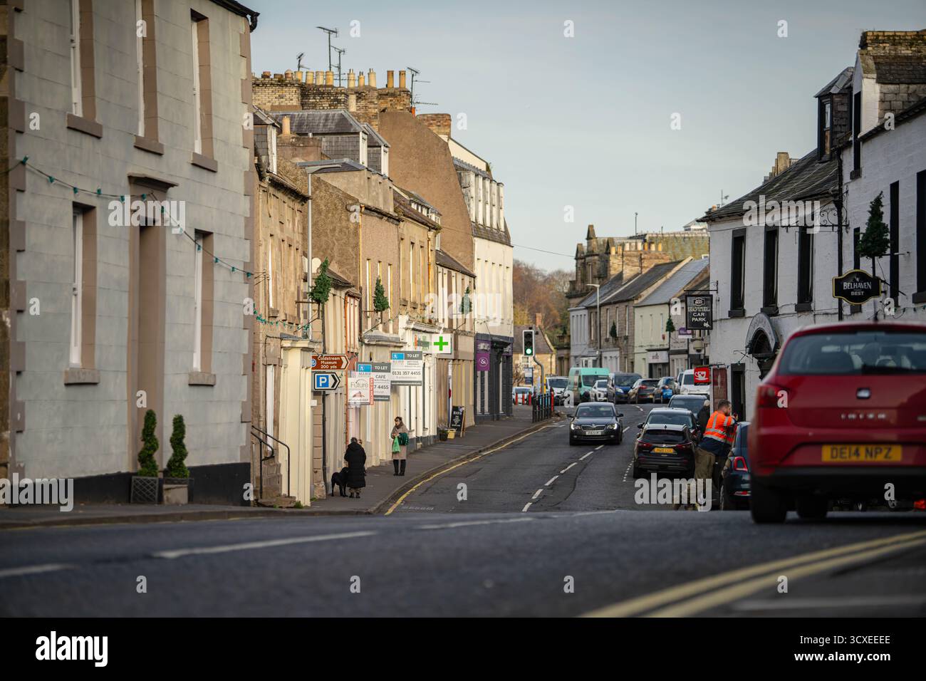 Blick auf die Straße entlang der High Street in Coldstream, einer historischen Stadt an der schottischen Grenze, Schottland, mit traditionellen Gebäuden, lokalen Geschäften und dem Schlepptau Stockfoto