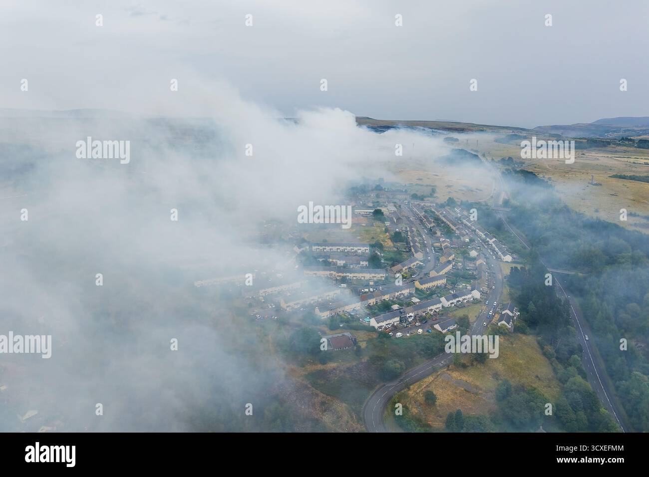 Dicker Rauch von einem Moorfeuer, der ein Wohngebiet in Wales überfällt Stockfoto