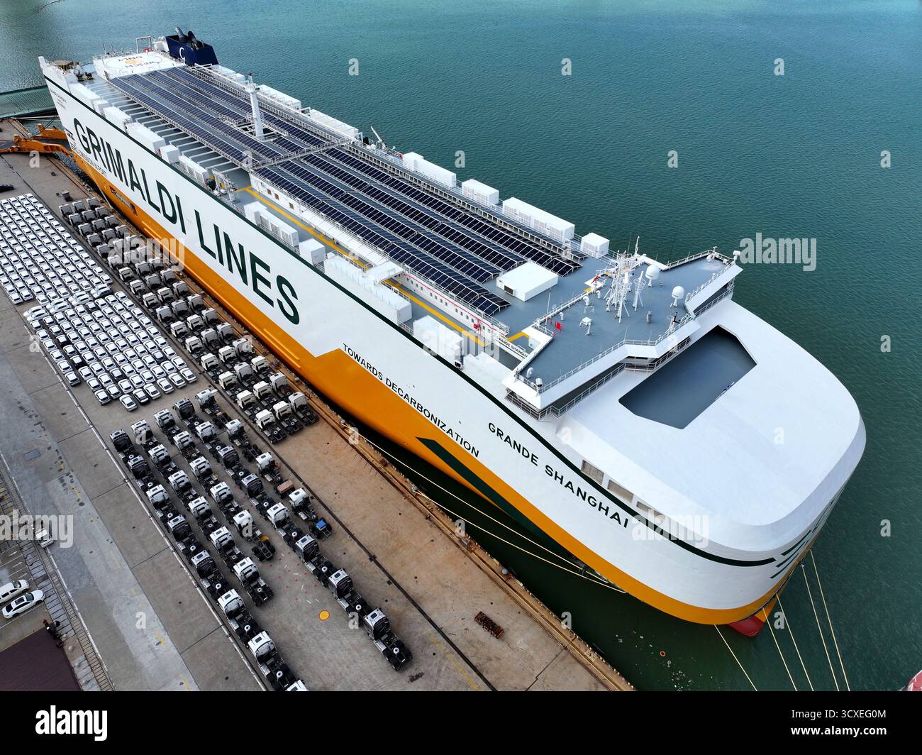 (251014) -- PEKING, 14. Oktober 2025 (Xinhua) -- ein Luftdrohnenfoto vom 14. Oktober 2025 zeigt Autos, die für den Transport bereit sind, neben einem Roll-on/Roll-off (RORO) Schiff an einem Kai in Lianyungang, ostchinesischer Provinz Jiangsu. Laut Branchendaten, die am Dienstag veröffentlicht wurden, hielt Chinas Sektor für neue Energiefahrzeuge (NEV) in den ersten neun Monaten des Jahres eine starke Dynamik in Produktion und Umsatz aufrecht. Die NEV-Produktion stieg im Vergleich zum Vorjahr um 35,2 Prozent auf 11,24 Millionen Einheiten in den ersten drei Quartalen, wie der China Association of Automobile Manufacturers (CAAM) berichtete. Umsatz während des Stockfoto