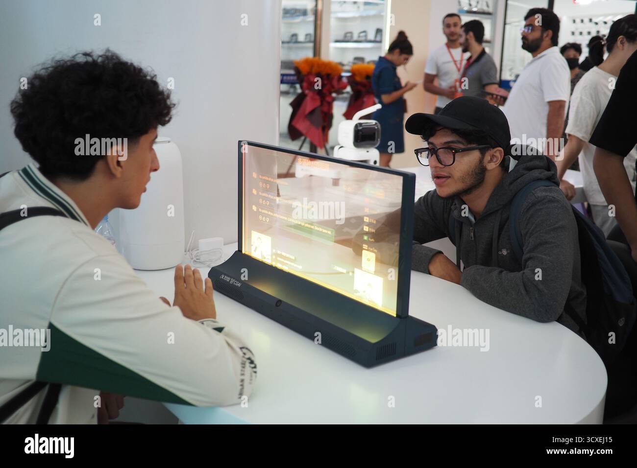 (251014) -- YIWU, 14. Oktober 2025 (Xinhua) -- ausländische Händler erleben ein interaktives KI-Übersetzungs-Gerät im Global Digital Trade Center in Yiwu, ostchinesischer Provinz Zhejiang, 14. Oktober 2025. Das Global Digital Trade Center, ein wegweisendes Projekt beim Bau des Marktes der sechsten Generation in Yiwu, wurde hier am Dienstag eröffnet. Dies markiert, dass Yiwu einen neuen Prozess des Übergangs vom traditionellen Handelsmodus zum digitalen Handelsmodus eingeleitet hat. Mit einer Fläche von 1,25 Millionen Quadratmetern nutzt das Global Digital Trade Center künstliche Intelligenz und digitale Tools, um das Kerngeschäft zu verbessern Stockfoto