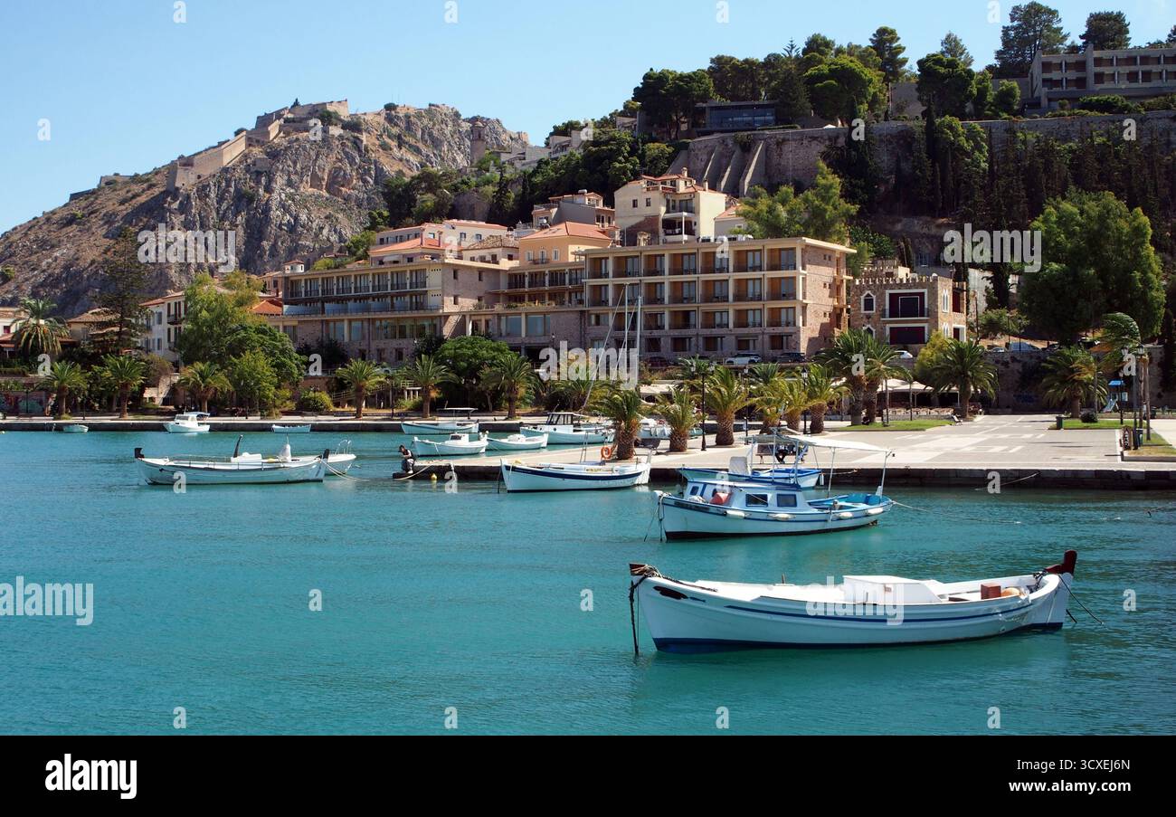 Weiße Boote, die auf türkisfarbenem Wasser im Hafen von Nafplio, Griechenland, schwimmen Stockfoto