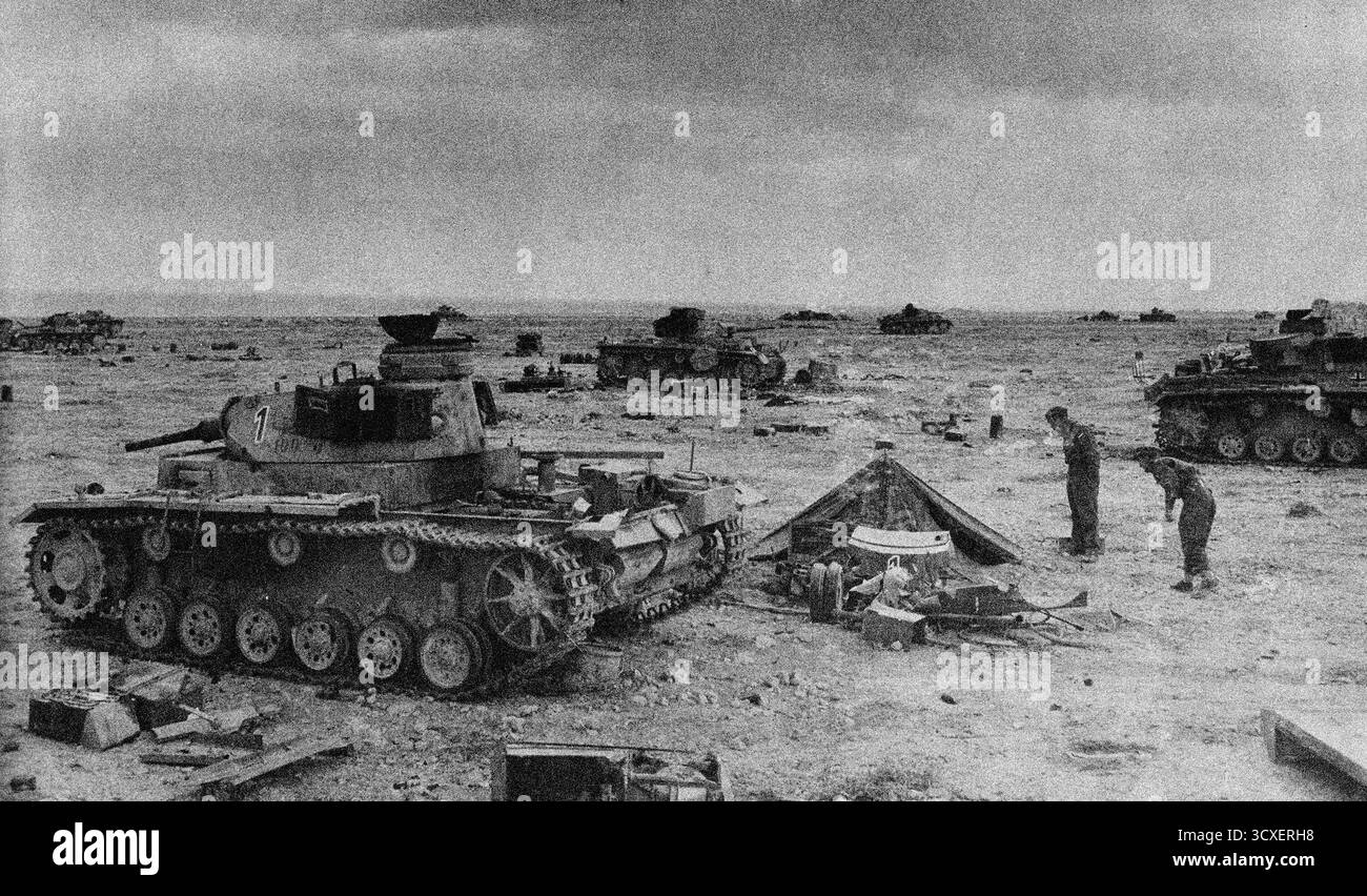 SIDI REGEZ, LIBYEN – 24. November 1941 – während der Operation Crusader untersuchen Soldaten der Achten Armee die Überreste des Schlachtfeldes bei Sidi Regez in der Westwüste Libyens. Die abgebildeten Panzer sind Tiger III aus der 15. Panzerdivision oder der 21. Panzerdivision, einige von vielen zerstört oder beschädigt in der Schlacht - Foto: Geopix Stockfoto