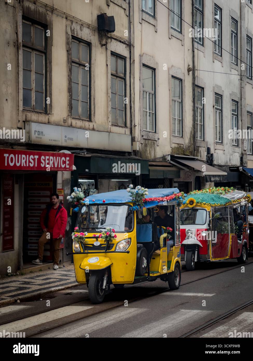 Farbenfrohe Tuk Tuks machen touristische Stadtrundfahrten in Lissabon, Portugal. Stockfoto