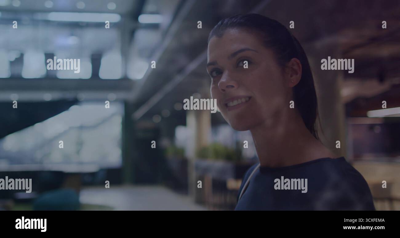 Stehende Geschäftsfrau im Büro, mit Glaswänden, Deckenleuchten und Liegestühlen, Kopierraum Stockfoto