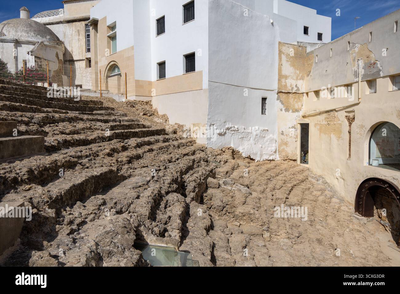Ein altes historisches Theater inmitten einer Stadt, umgeben von Häusern. Dieses Wahrzeichen wurde tagsüber fotografiert. Teatro Romano de Cdiz, Andalusien Stockfoto