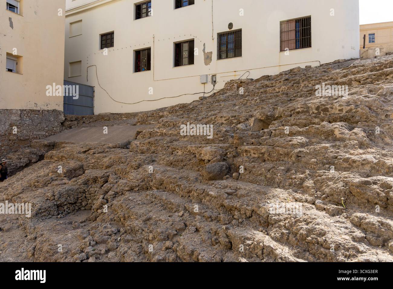 Ein altes historisches Theater inmitten einer Stadt, umgeben von Häusern. Dieses Wahrzeichen wurde tagsüber fotografiert. Teatro Romano de Cdiz, Andalusien Stockfoto