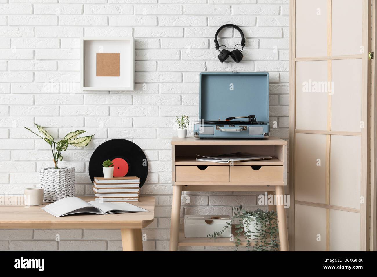 Das Innere des stilvollen Wohnzimmers ist mit Plattenspieler und Vinylplatten auf Holztischen ausgestattet Stockfoto
