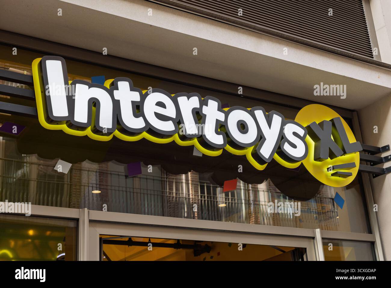Nahaufnahme des Intertoys XL-Logos und der Ladenwerbung mit auffälligen weißen und gelben Schriftzügen und einem lustigen, verspielten Design. Stockfoto