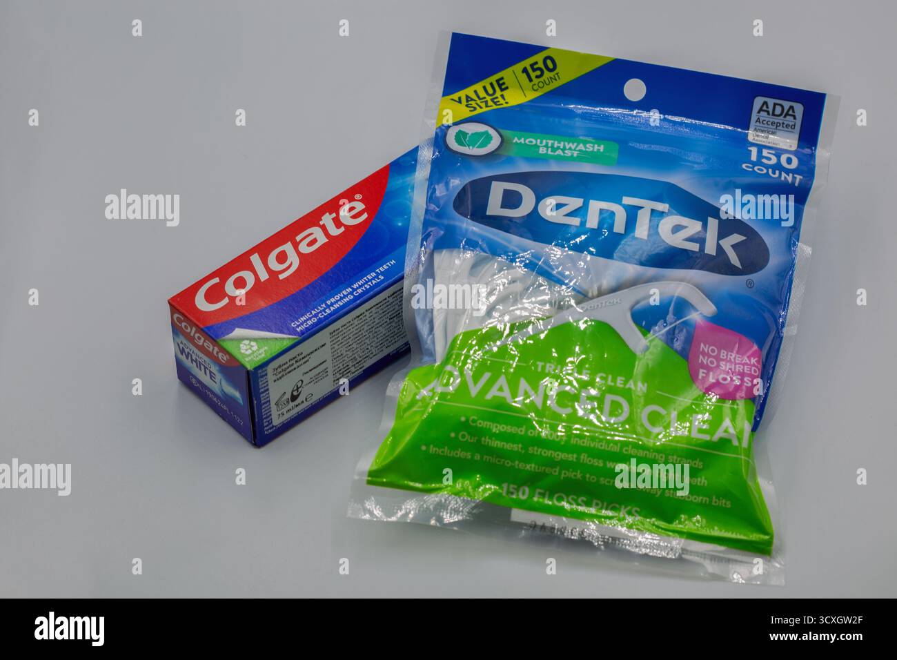 Kiew, Ukraine - 02. Februar 2025: Colgate Zahnpasta und DenTek Advanced Clean Floss Picks zeigen Nahaufnahme auf einer neutralweißen Oberfläche, Ref Stockfoto