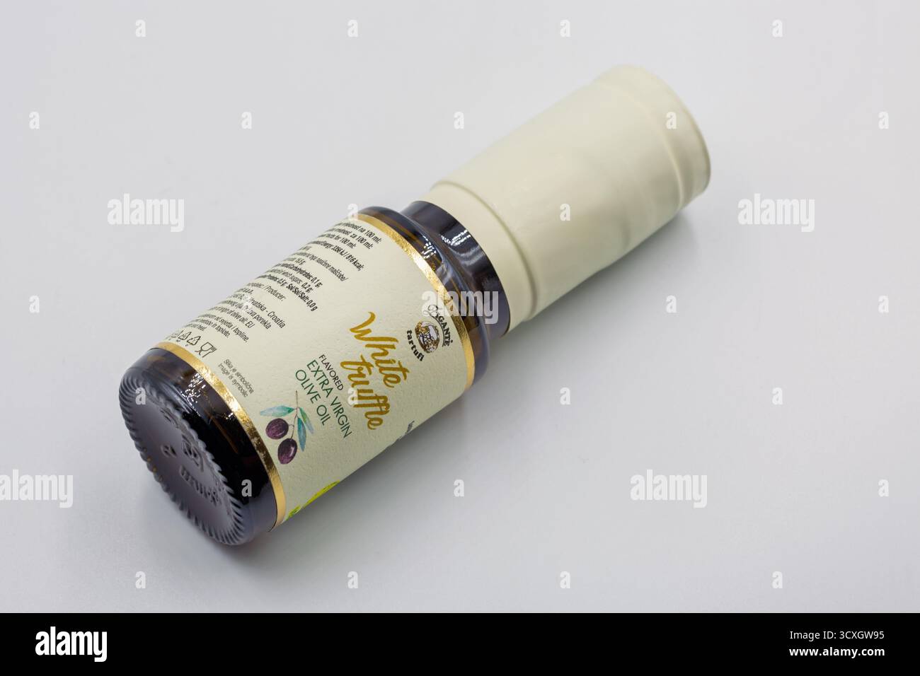 Porec, Kroatien - 29. Mai 2025: Hochwertiges natives Olivenöl mit weißer Trüffel in kleiner brauner Glasflasche mit elegantem goldenem Schriftzug Stockfoto