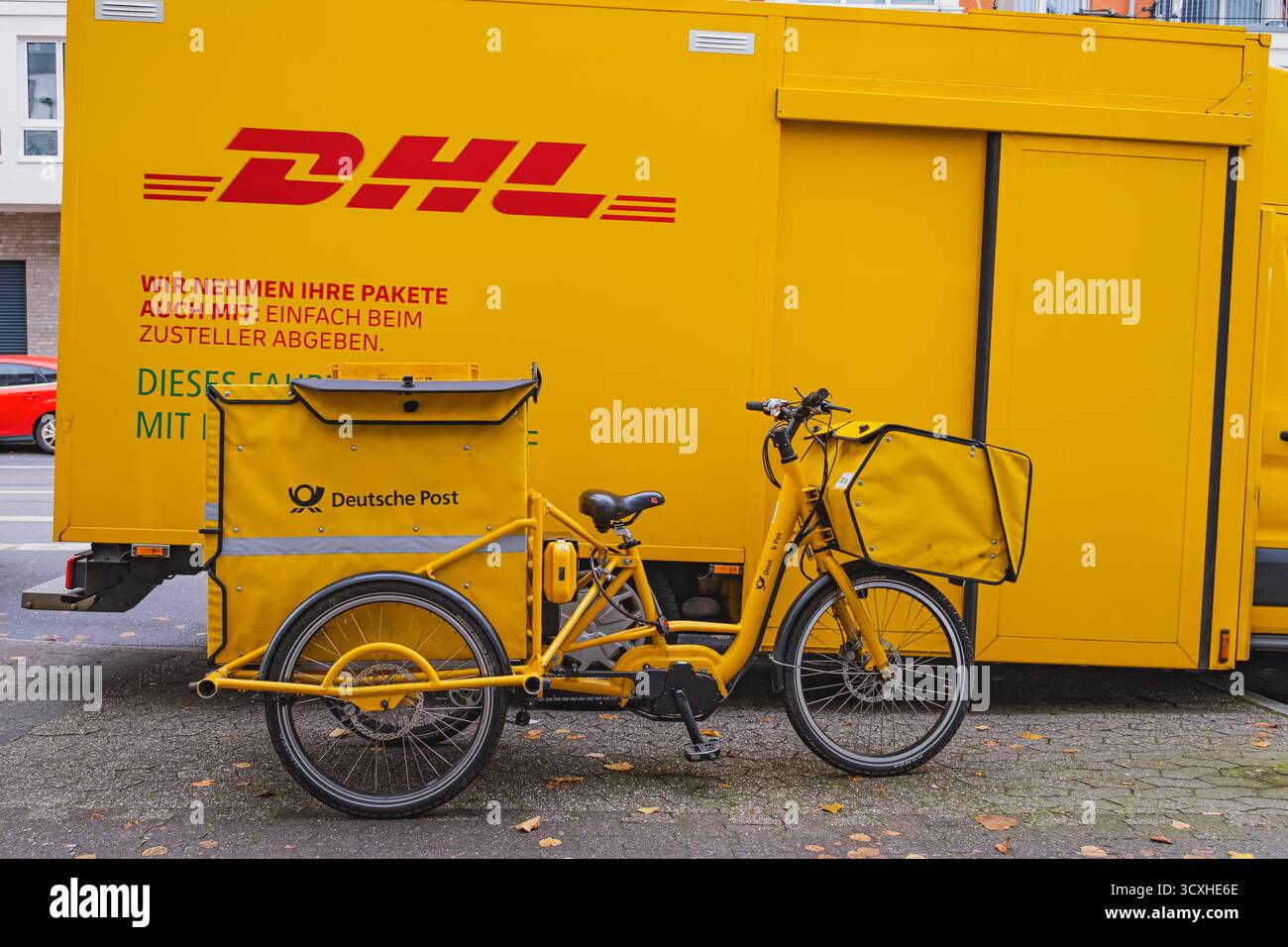 Gelber DHL-Lieferwagen mit Lieferfahrrad der Deutschen Post davor geparkt Stockfoto