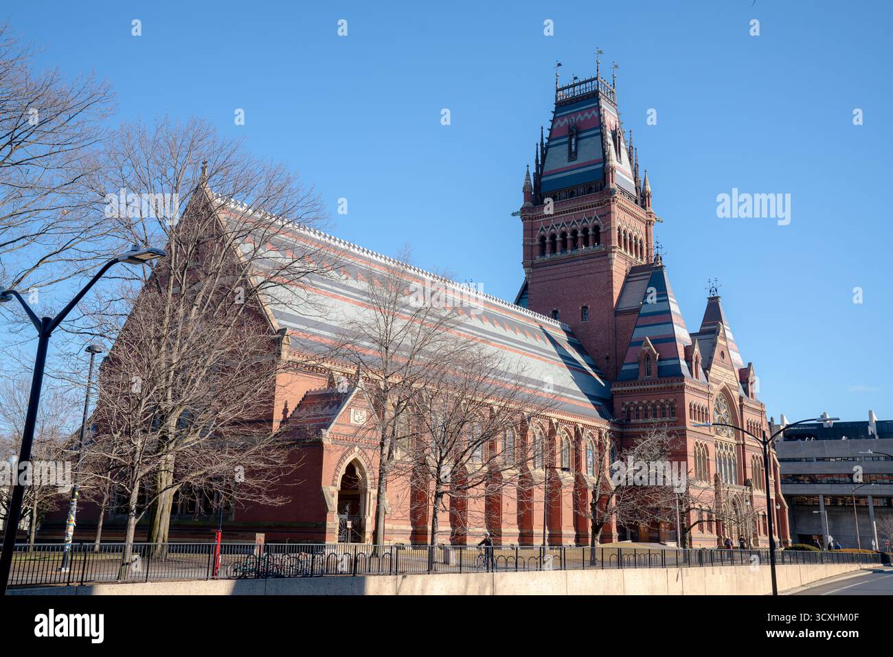 Cambridge, MA, USA – 19. Januar 2025: Eine Seitenansicht der Memorial Hall an der Harvard University zeigt gotische architektonische Details unter einem klaren blauen Himmel Stockfoto