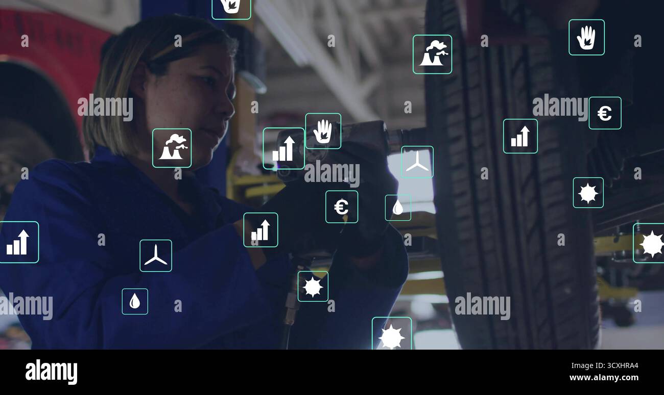 Mechaniker in Overalls, der Schlagschrauber an Radmuttern in der Werkstatt betätigt, mit schwimmenden Datensymbolen Stockfoto