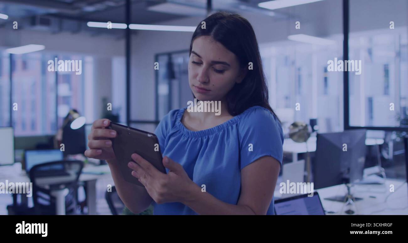 Professioneller Standplatz in der Hand eines Tablets im Großraumbüro mit Laptop, Monitoren und ergonomischem Stuhl Stockfoto