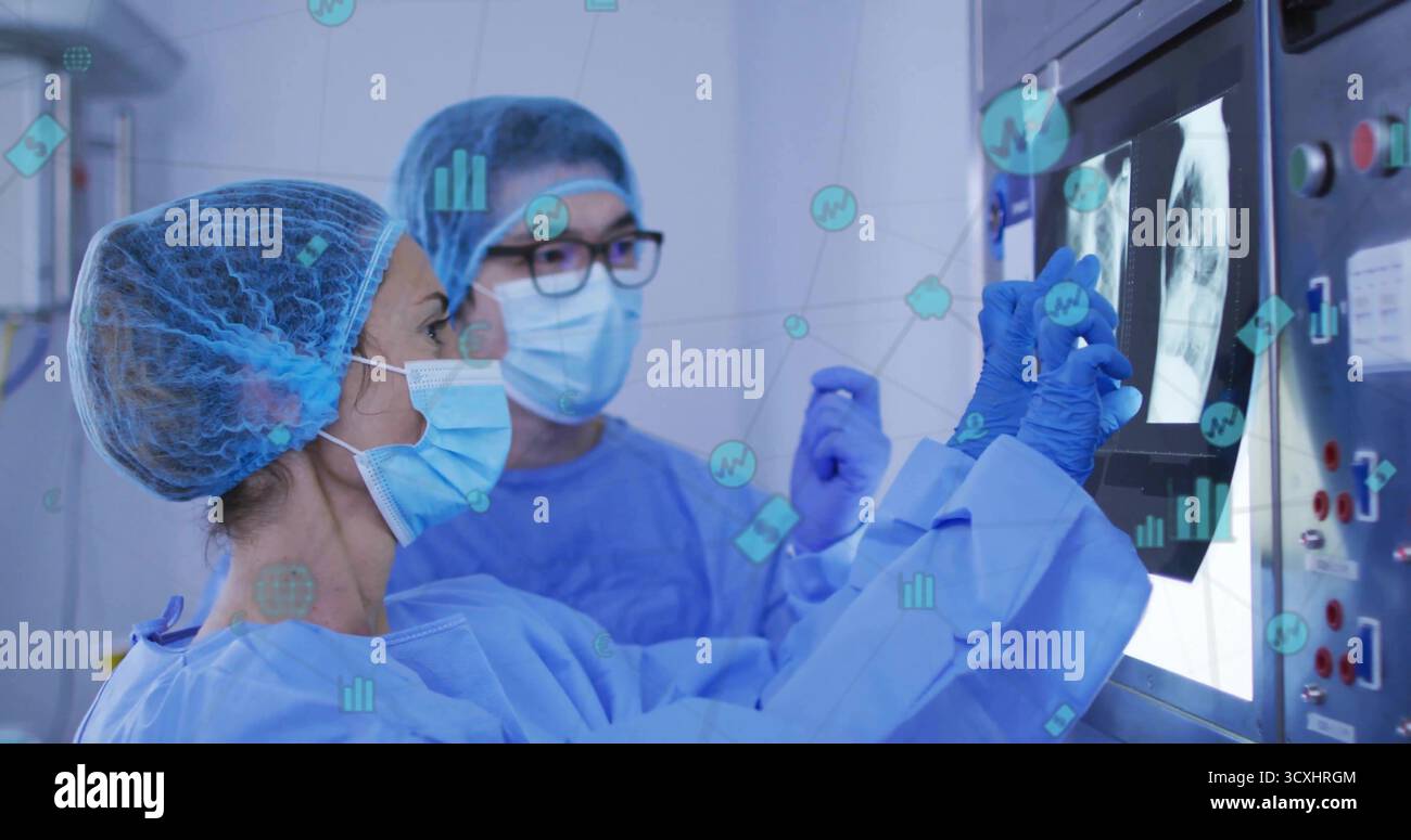 Untersuchung von Kollegen in blauen Peelings, die die Thoraxröntgenuntersuchung im Radiologieraum mit Datenüberlagerungen besprechen Stockfoto