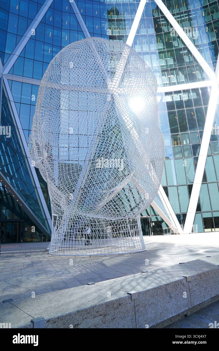 Das Sonnenlicht scheint durch die Wonderland-Skulptur von Jaume Plensa vor dem Bow-Gebäude und hebt das Stahlgitter in der Skyline von Calgary hervor Stockfoto