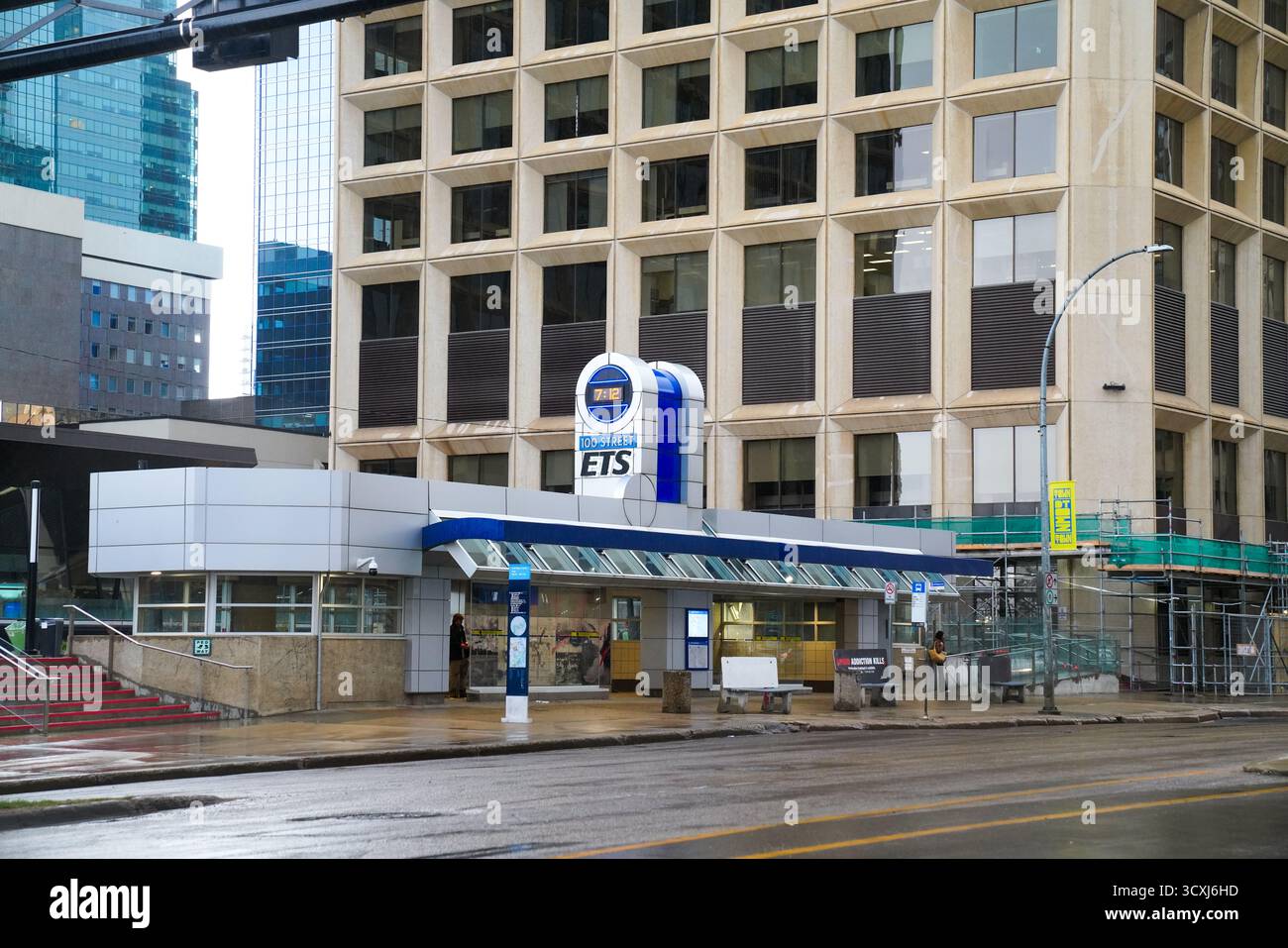 Der Eingang zum 100 Street Edmonton Transit System (ETS) befindet sich in der Innenstadt von Edmonton, umgeben von Hochhäusern und feuchten Straßen nach Regenfällen Stockfoto