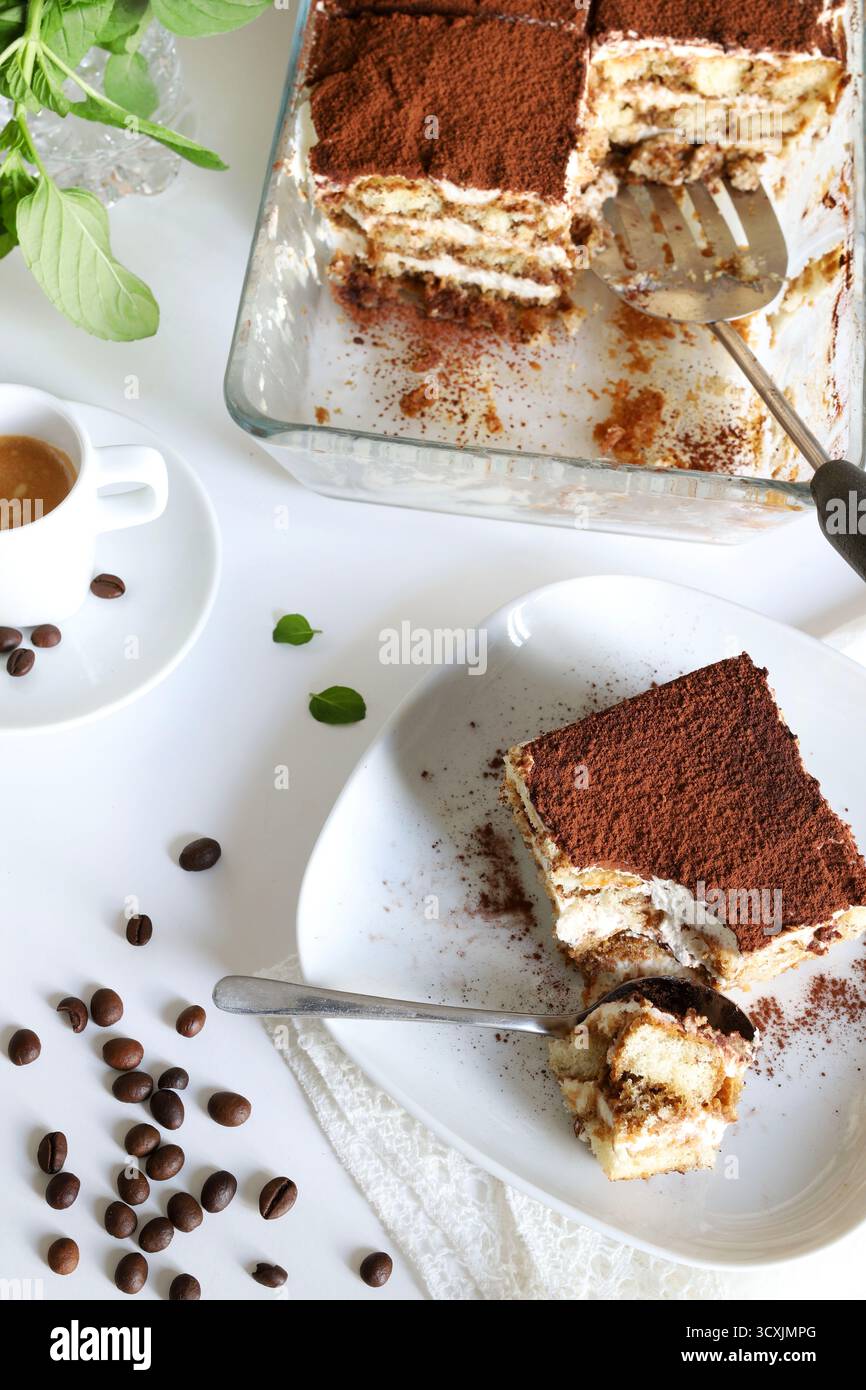 Tiramisu. Klassisches Kaffee-Tiramisu mit Marienfinger und Mascarponcreme, bestreut mit Kakaopulver auf weißem Hintergrund. Italienisches Dessert. Stockfoto