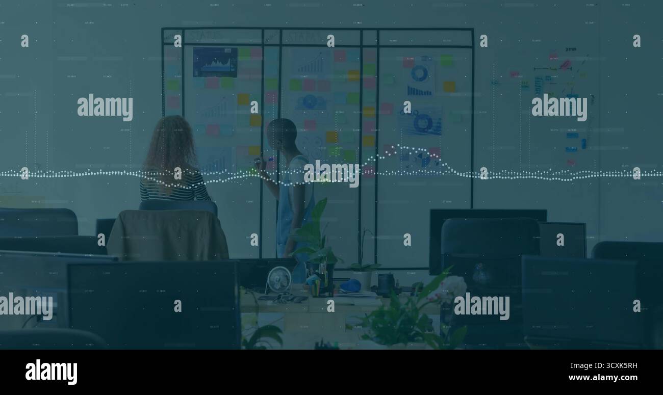 Brainstorming-Kollegen in lässiger Kleidung, die Haftnotizen auf der Trennwand im Büro anmerken Stockfoto